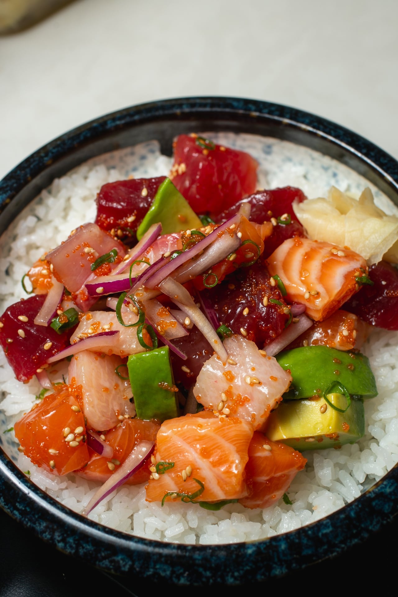 A poke bowl with ahi, salmon and avocado over rice